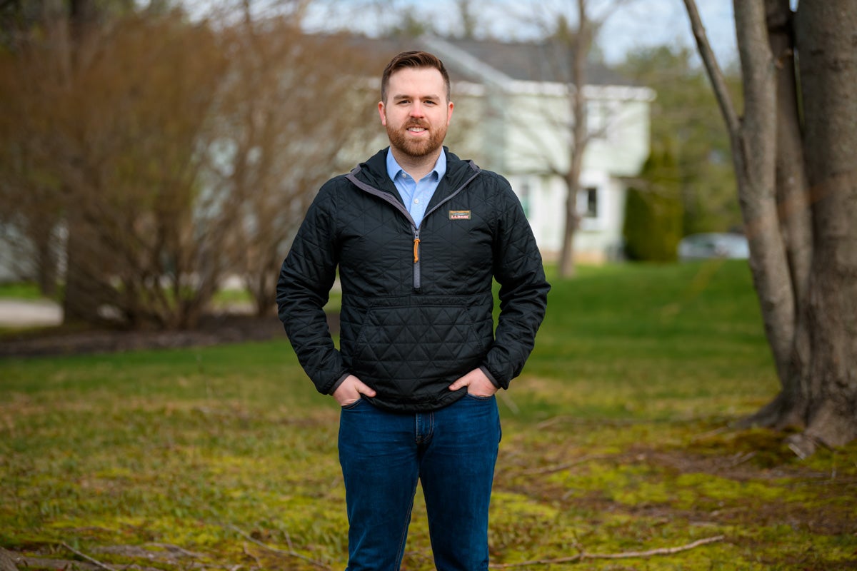 Ryan Fecteau standing outside with a duplex house in the background, in Biddeford