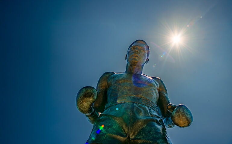 Muhammad Ali statue in Lewiston against blue sky background.
