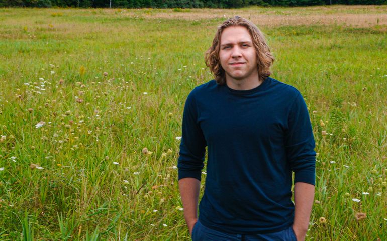 portrait of 20-something man standing in a field