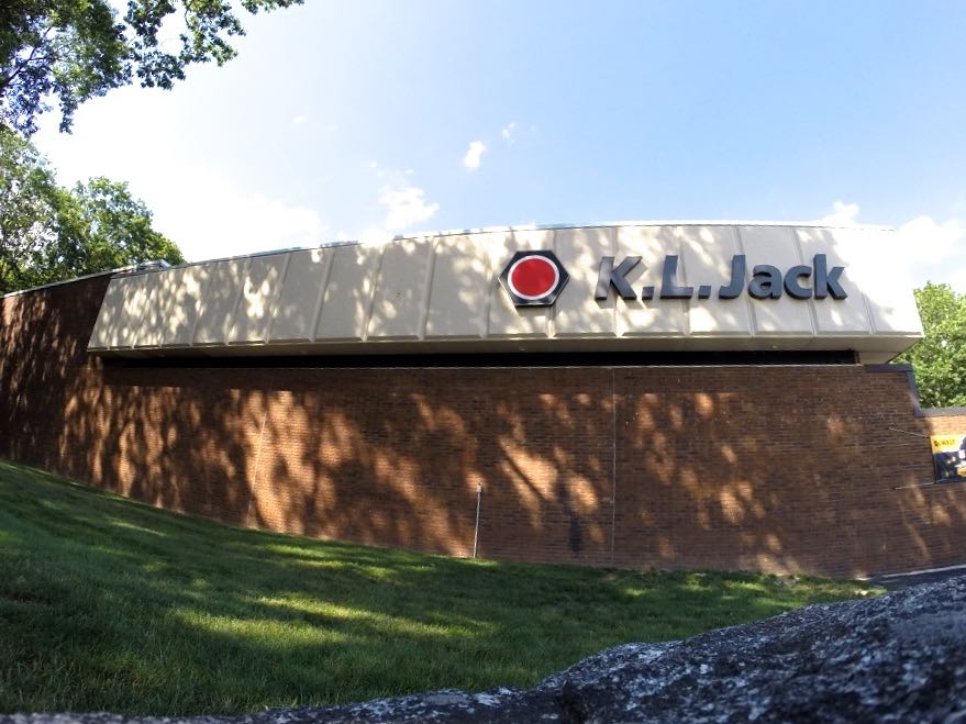 A building has signage on it and a tree next to it.