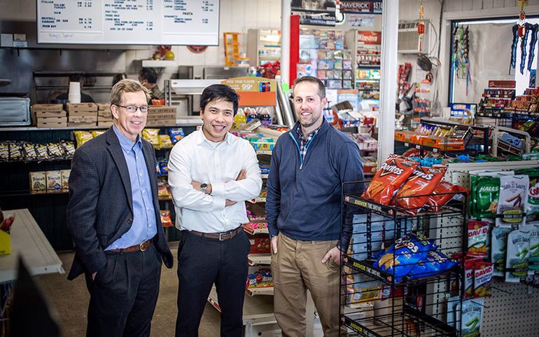 Three men standing in a convenience store