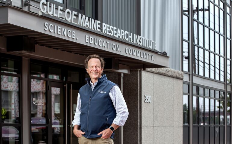 person smiling standing outside building entryway
