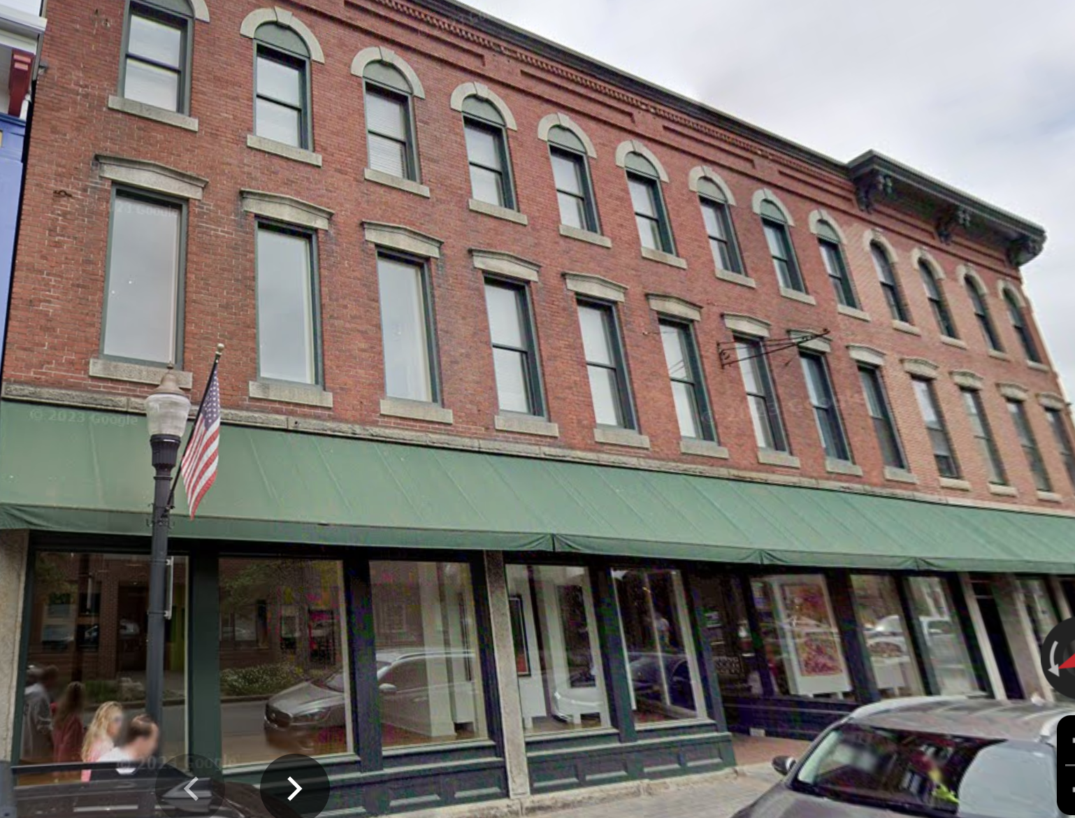 An exterior view of a brick building with storefront windows.