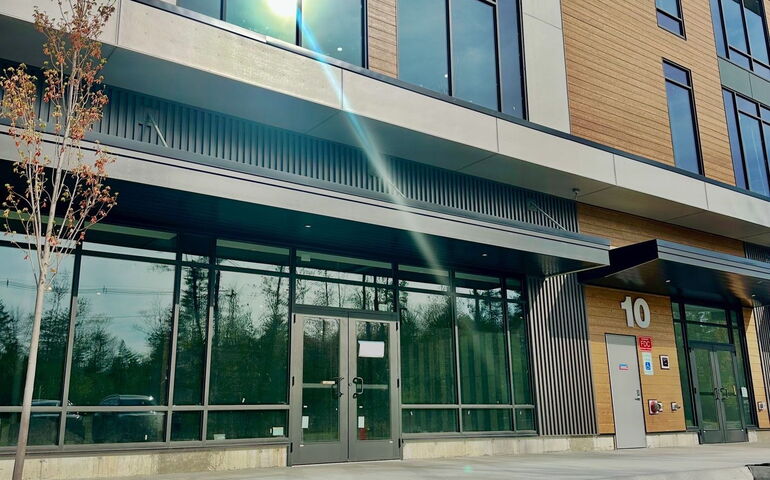 An exterior view of an entryway with big windows.