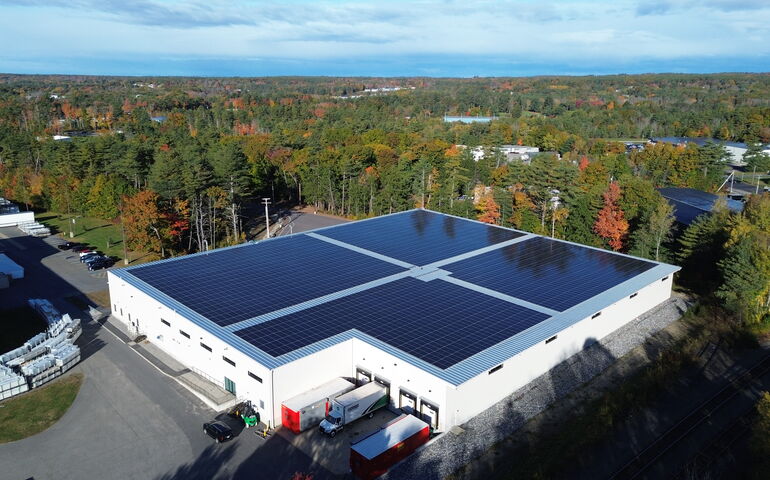 An aerial view of a flat-roofed building with solar panels.