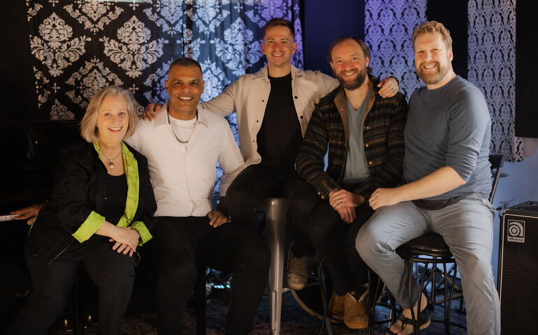 Five people pose in a studio.