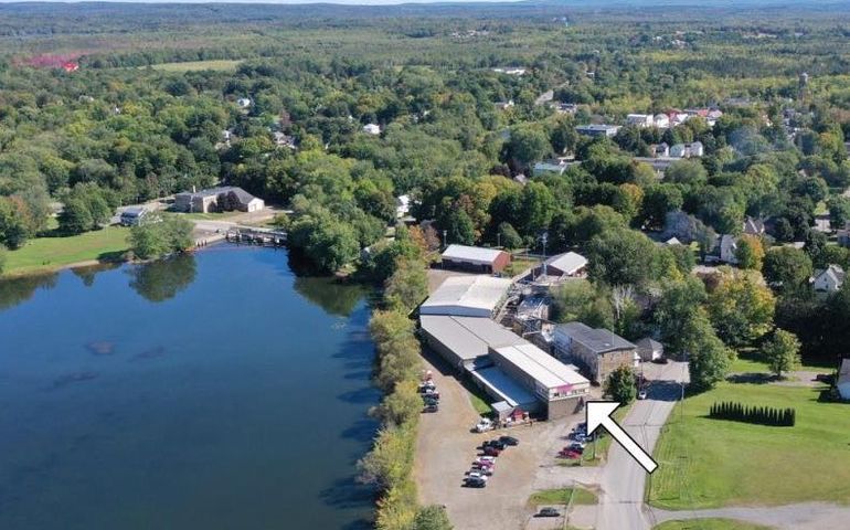 aerial of buildings and lake with arrow