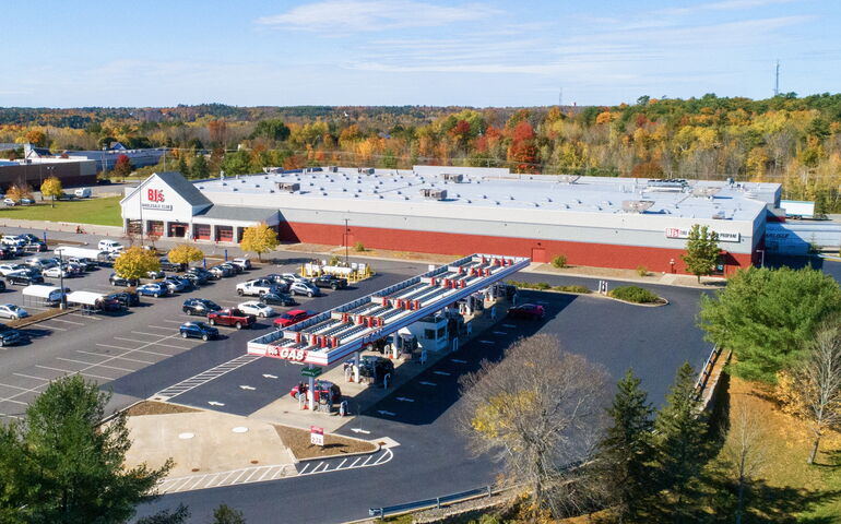 An aerial view shows a large building with a parking lot.