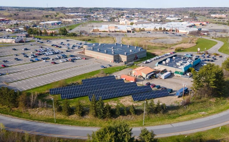 aerial of buildings with rows of lots of solar panels