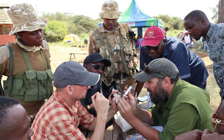 People look at work being done by researchers.