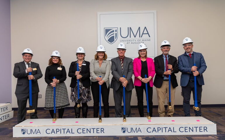 Folks pose in a line with shovels.