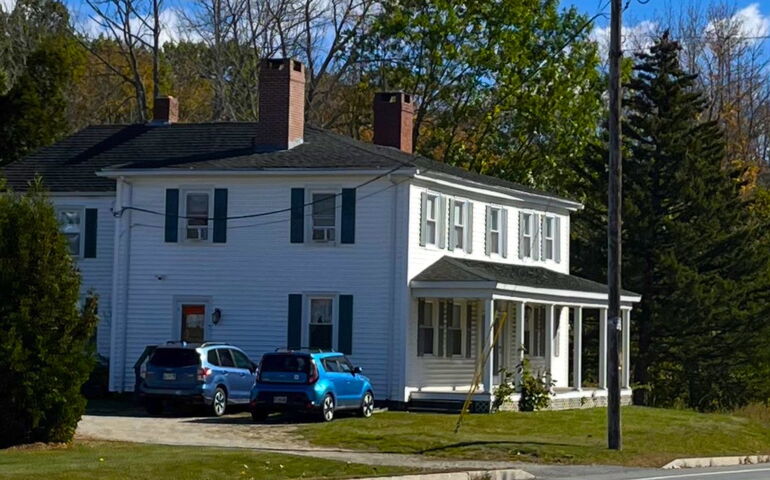 A house has white siding and black shutters.