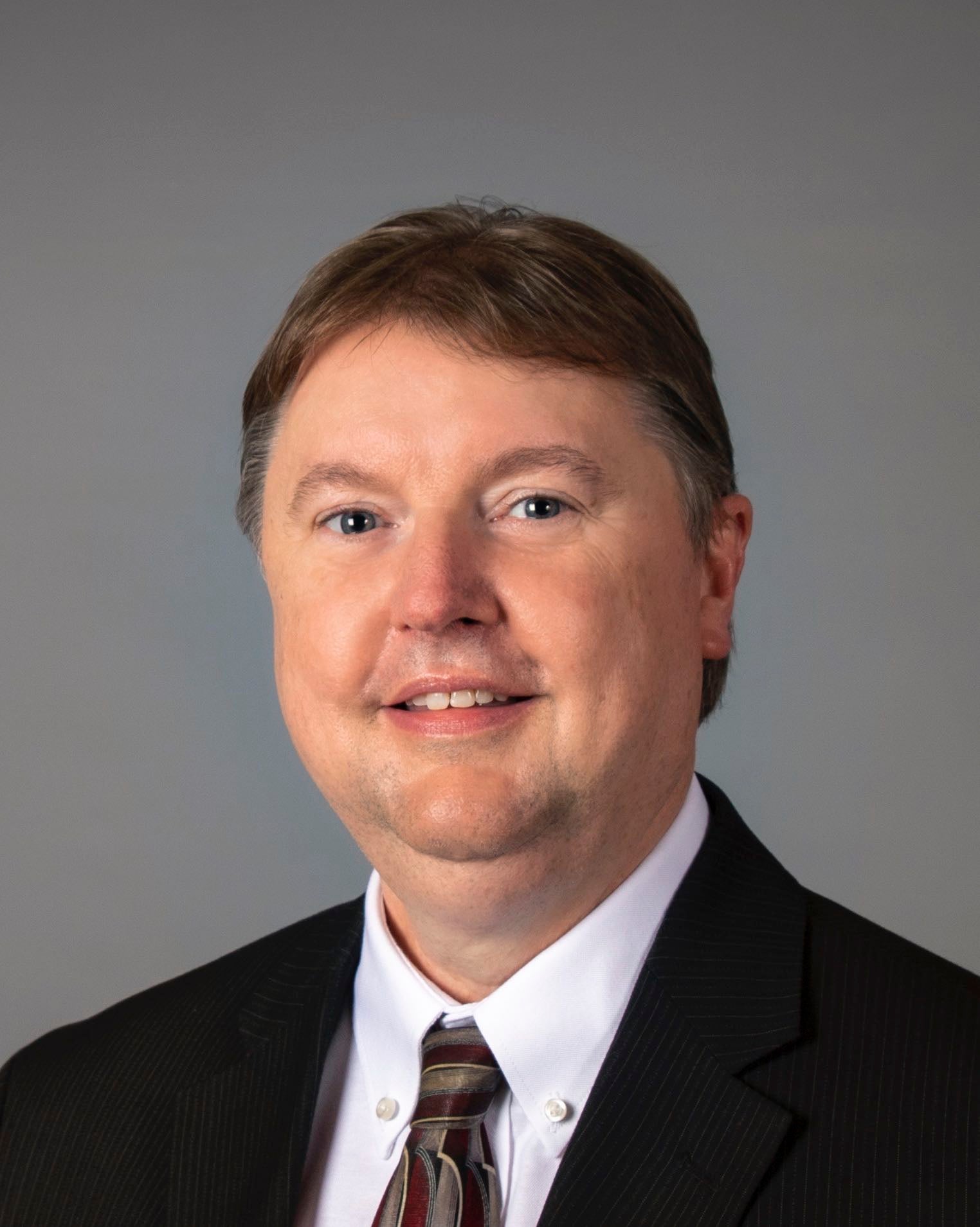 A person poses for a headshot.