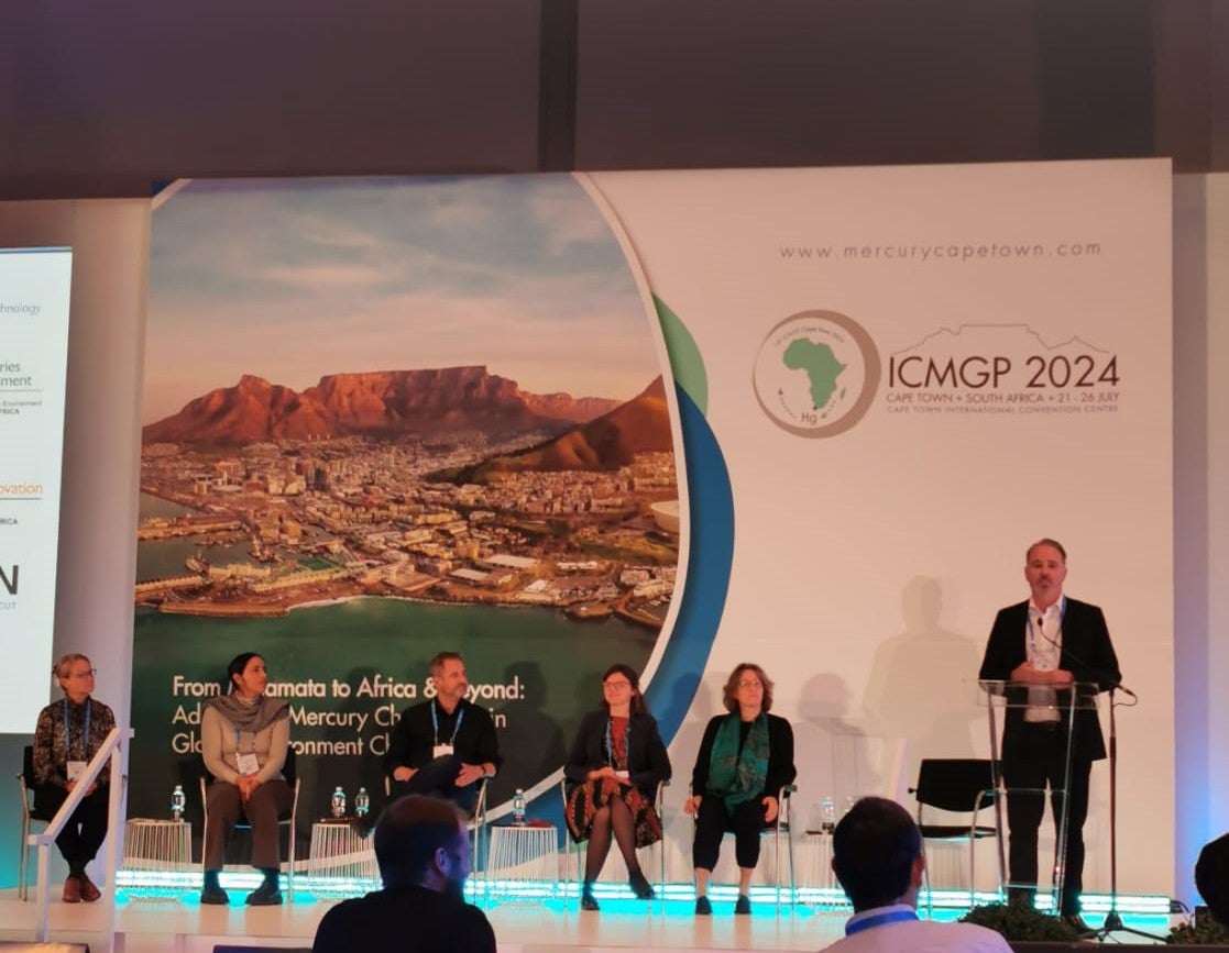 David Evers speaks at a lectern while others listen.
