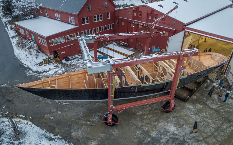 An aerial view shows a partly built boat and buildings.