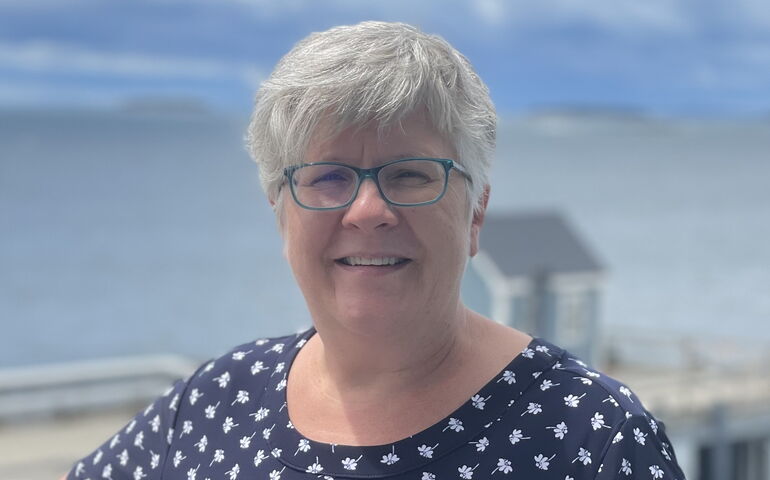 A person poses by the water.