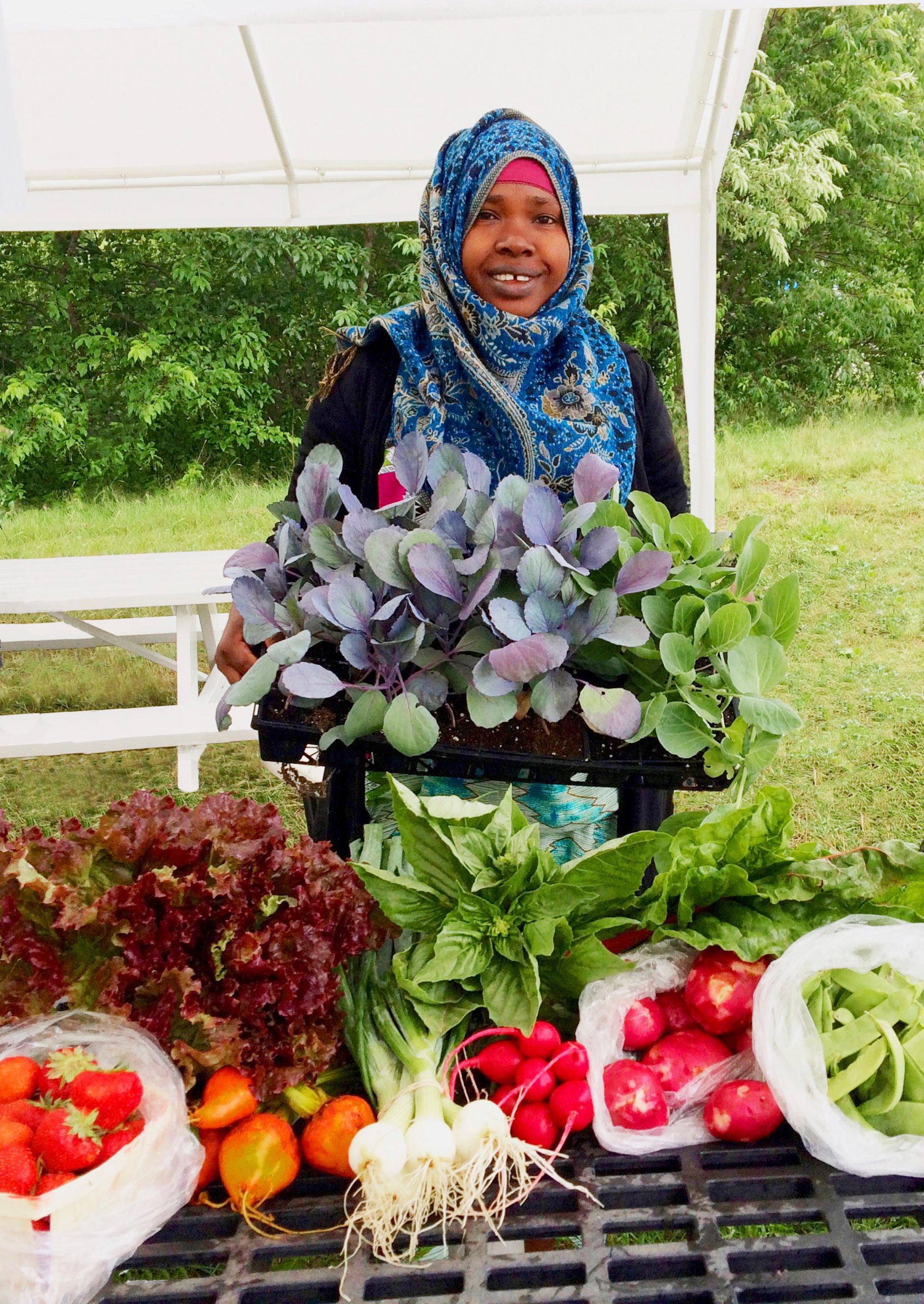 A farmer shows some of her crops.
