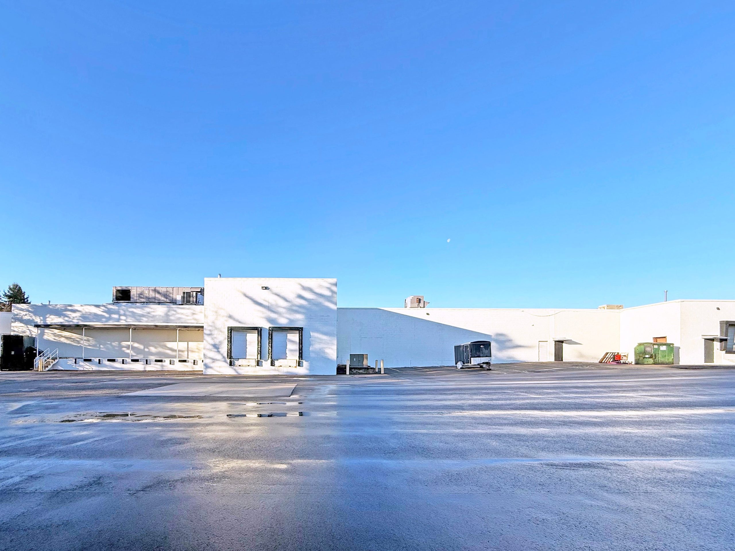 An exterior view of a long, low white building.