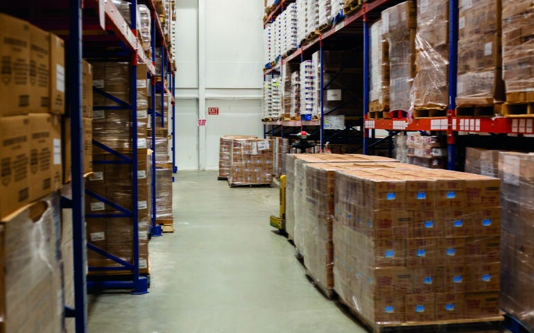 A warehouse contains shelving and boxes.