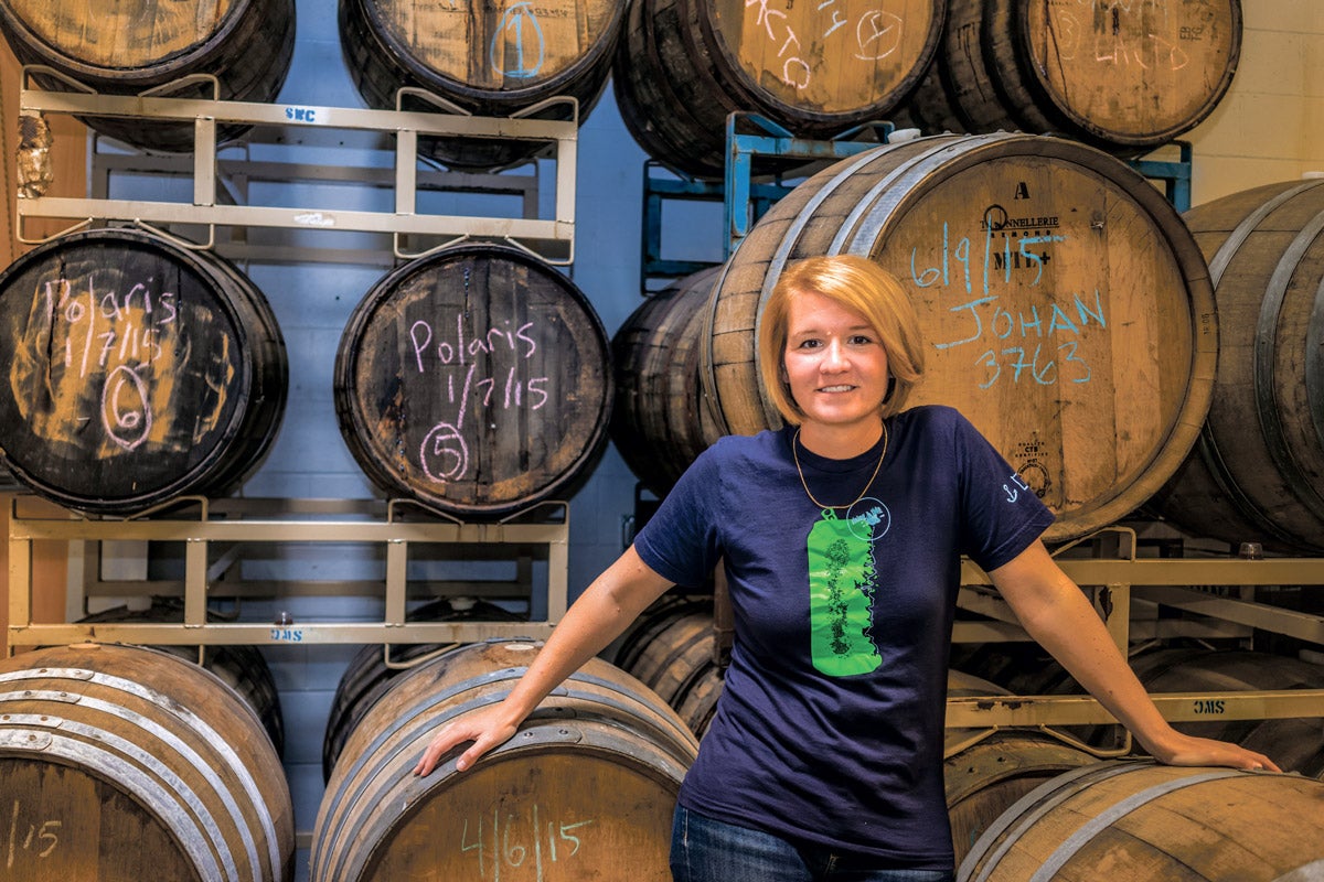 Portrait of Heather Sanborn in front of wooden barrierls