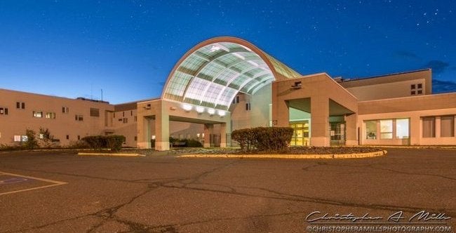 An exterior view of a building with an arch and portico.