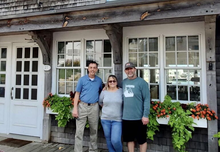 3 people standing in a line in front of singled building
