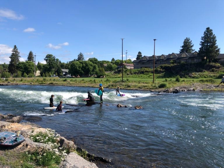 People are riding vessels on a river.