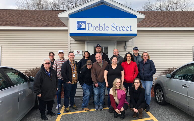 A group of people stands outside of Preble Street's buildling.