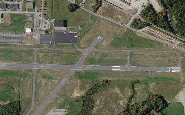 An aerial view of bare ground and straight pavement.