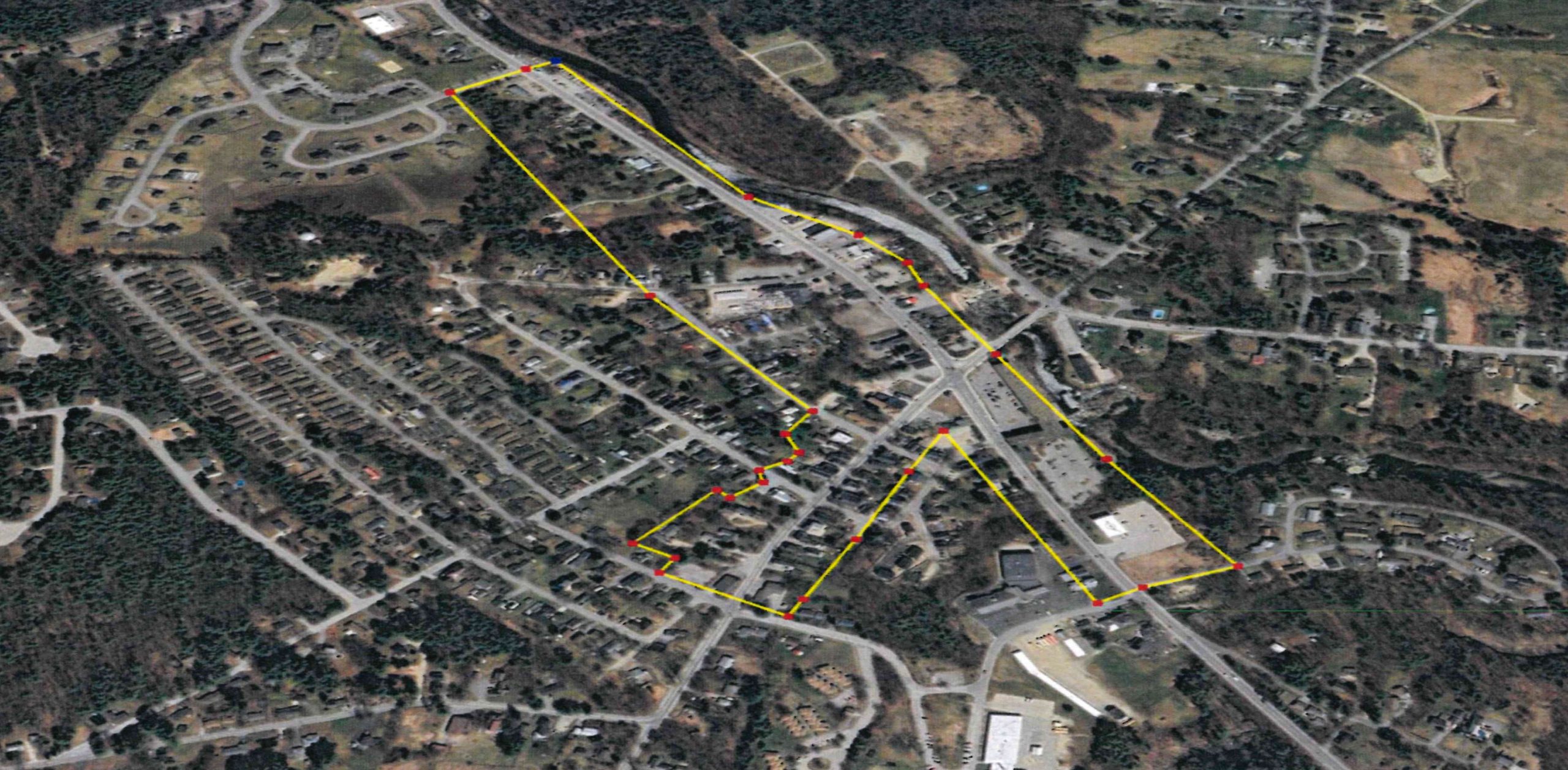 An aerial view of streets and woods with an outline.