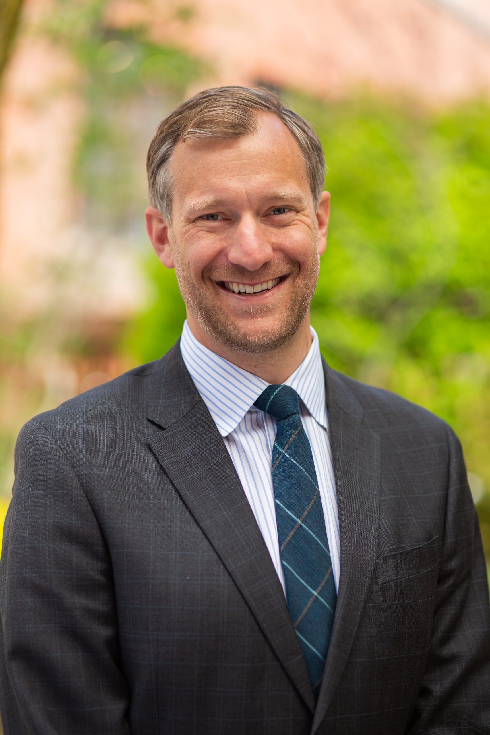 smiling person in suit and tie and face fuzz