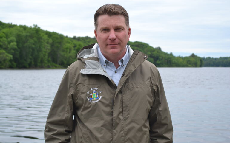 A person  poses near the water.