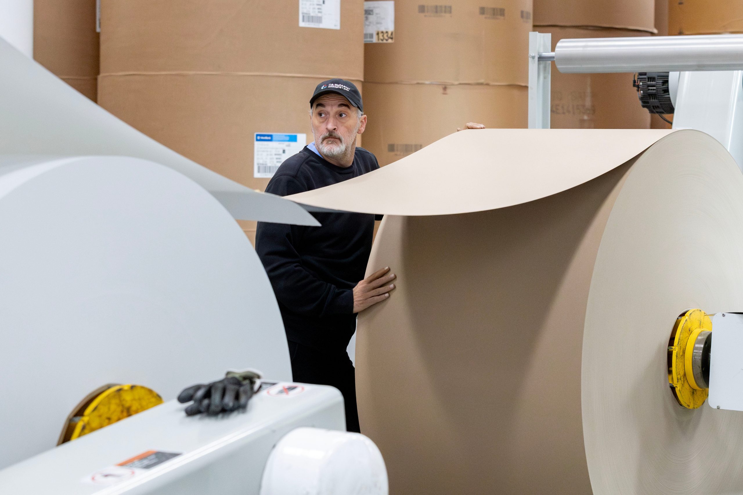 A person is working with big rolls of paper.