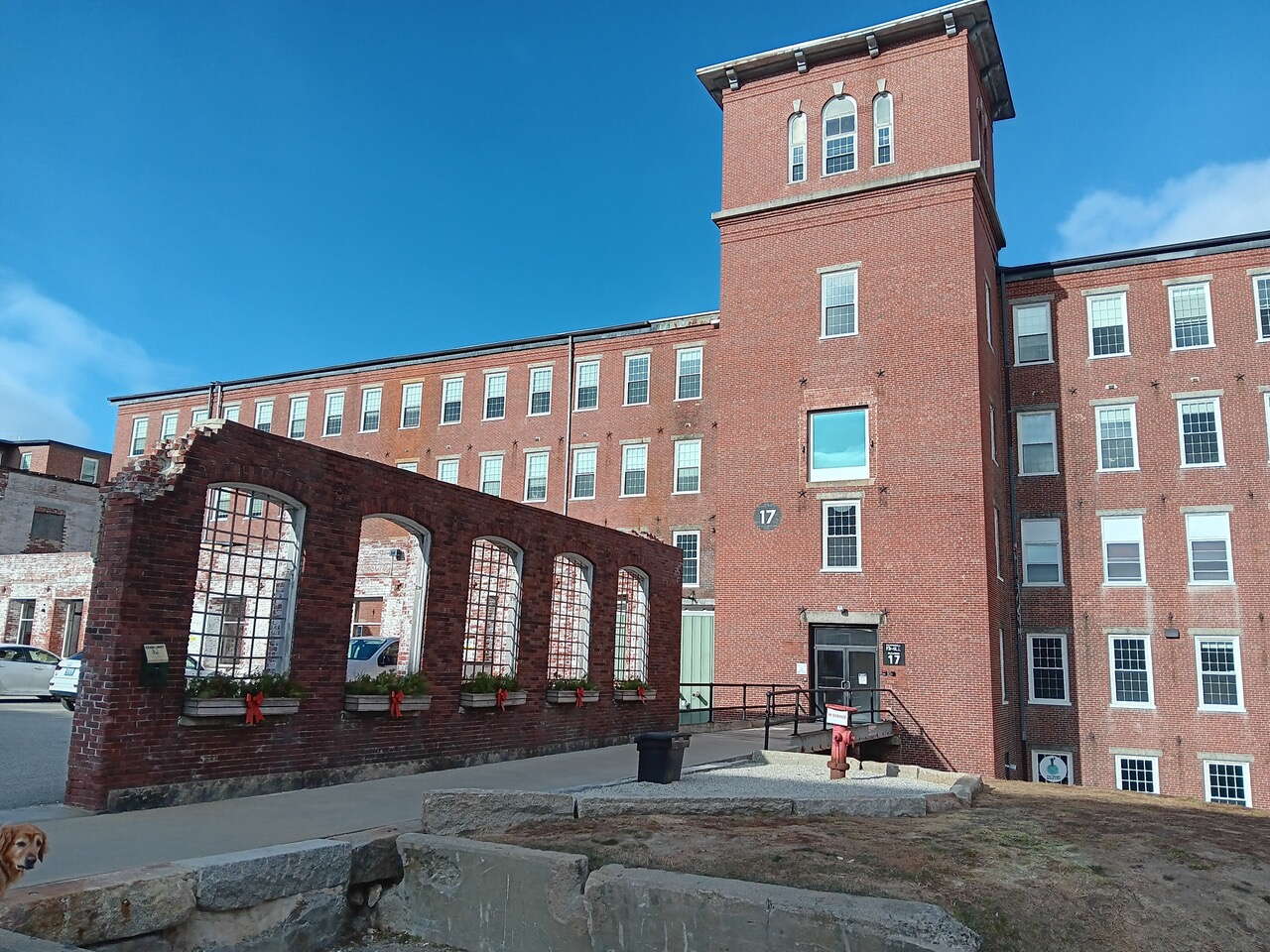 A brick building has brick and concrete structures in front of it.