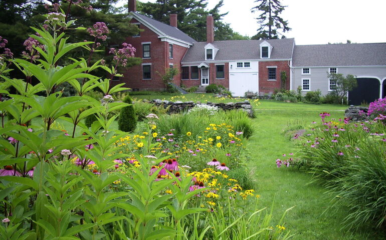 The Frances Perkins House is shows with nice landscaping and flowers.