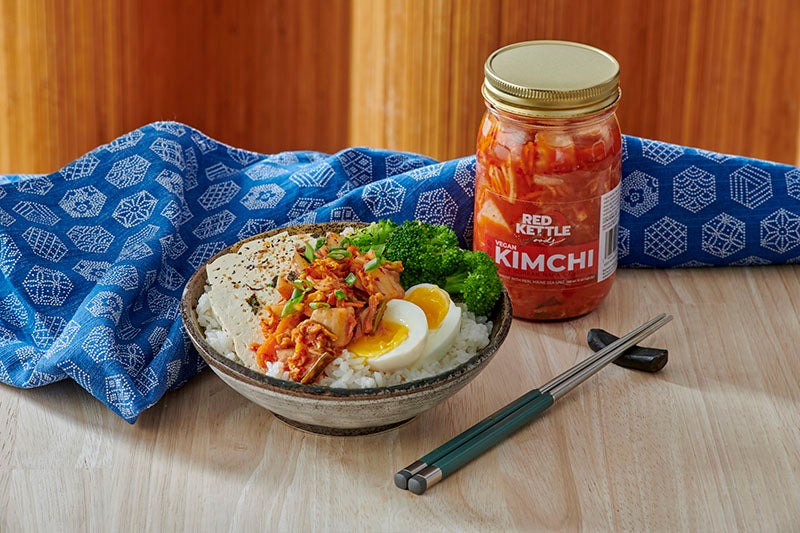 A jar of kimchi and a bowl of food.