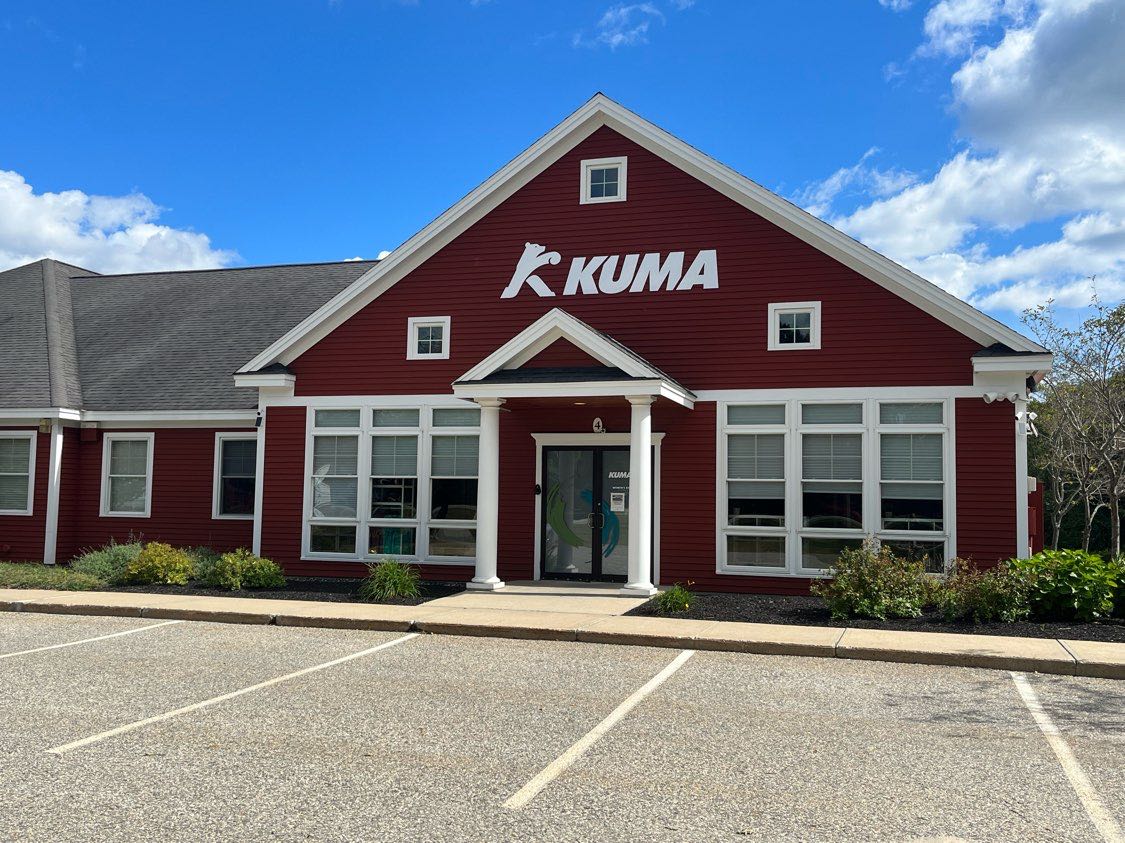 red building with white trim and parking lot