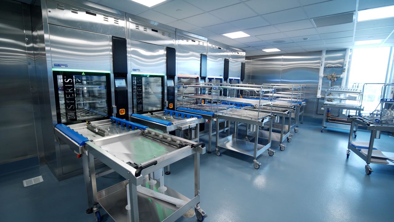 A room contains gleaming metal equipment and tables.