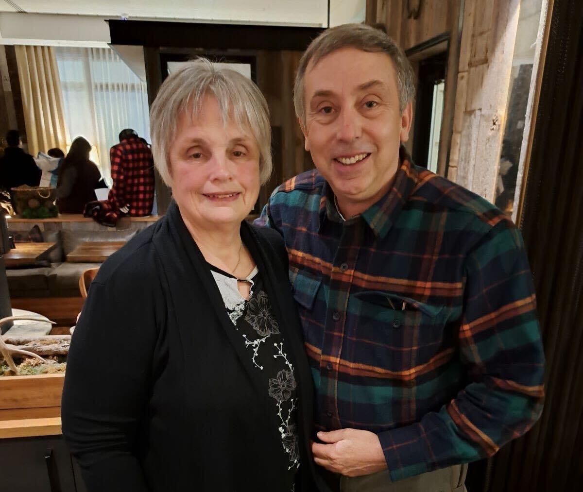 Two people pose in a room.