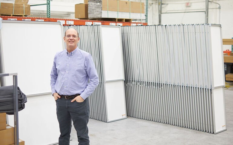 person with hands in pockets standing in front of panels