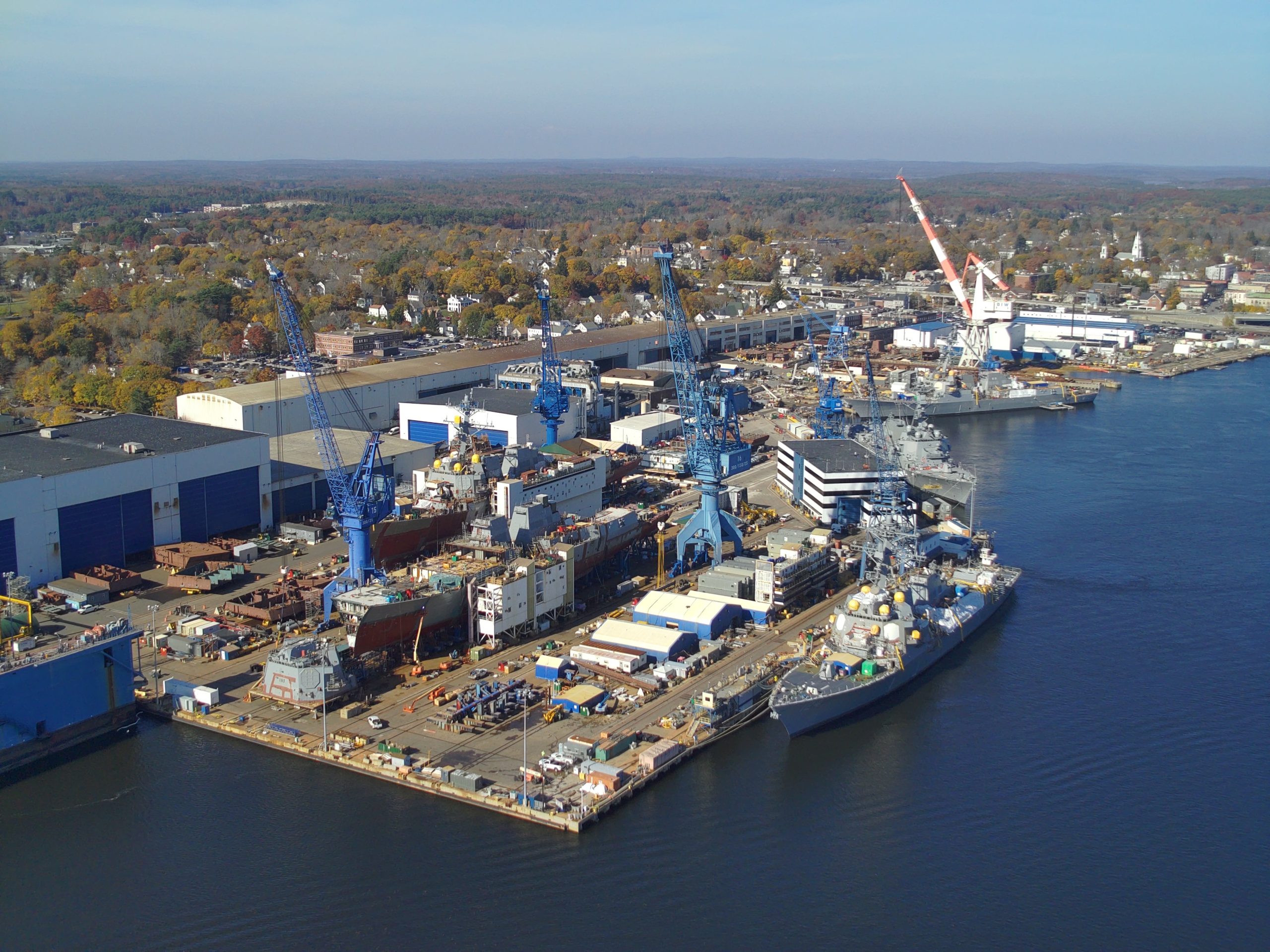 An aerial view of an i ndustrial complex next to water.