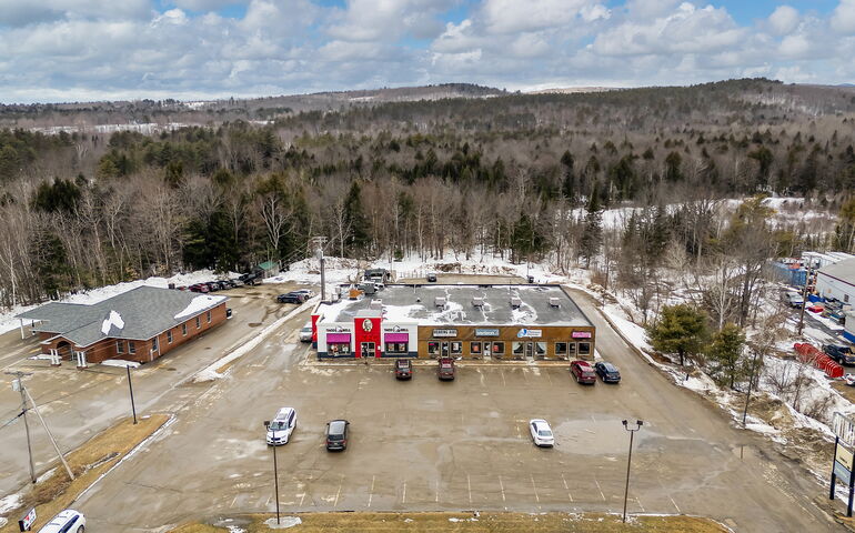 An aerial view shows buildings and  a parking lot.