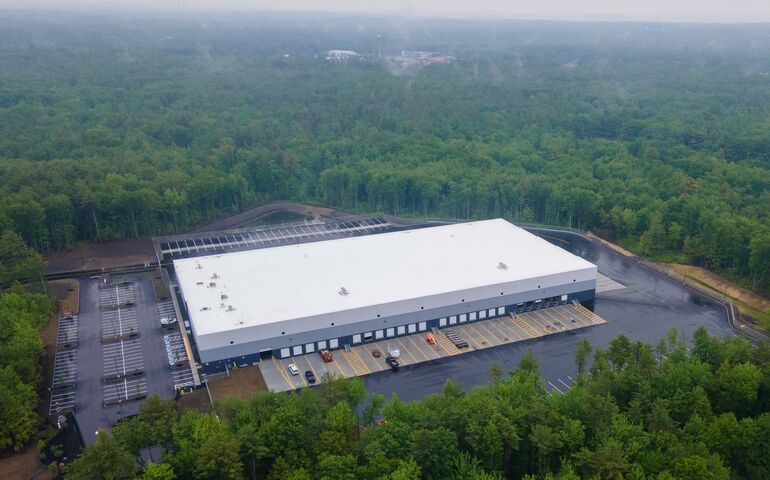 aerial of big new building parking lot woods