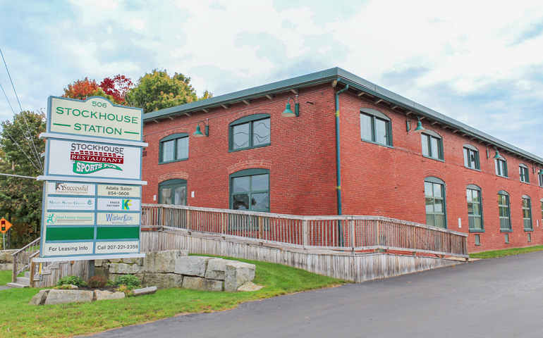A rectangural brick building has a ramp and signage.