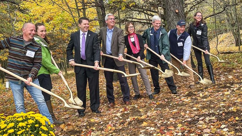 people in a line holding shovels