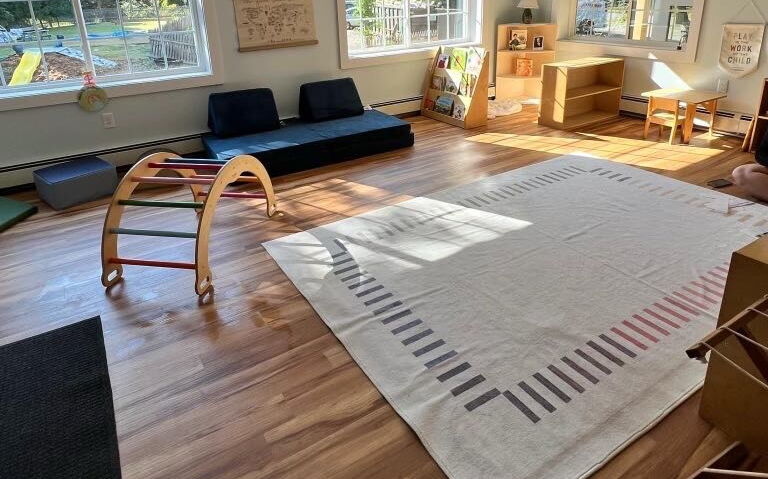 A classroom wtih furnishings and a carpet.