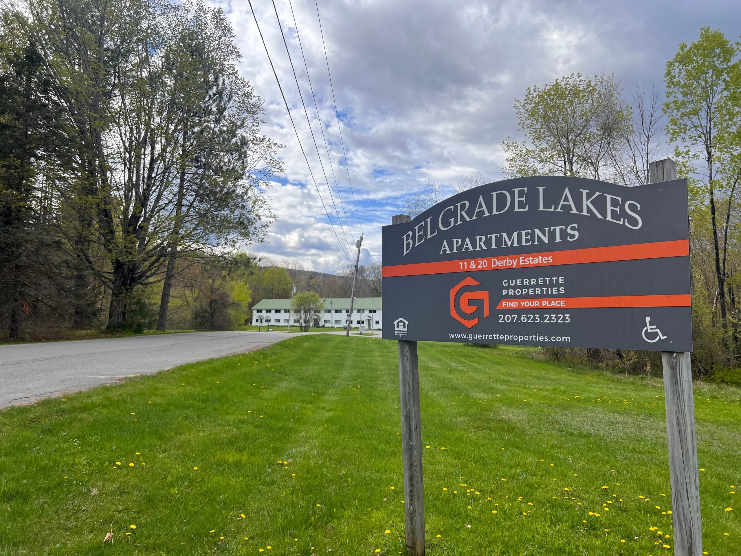 building in background with lawn and sign in foreground