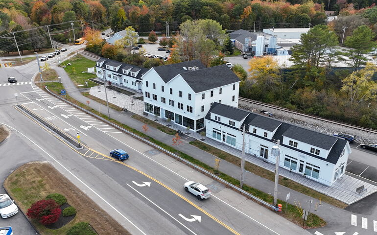 An aerial view of long low white buildings and roads.