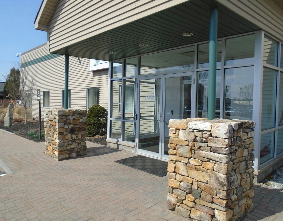 entry with glass doors and rock pillars