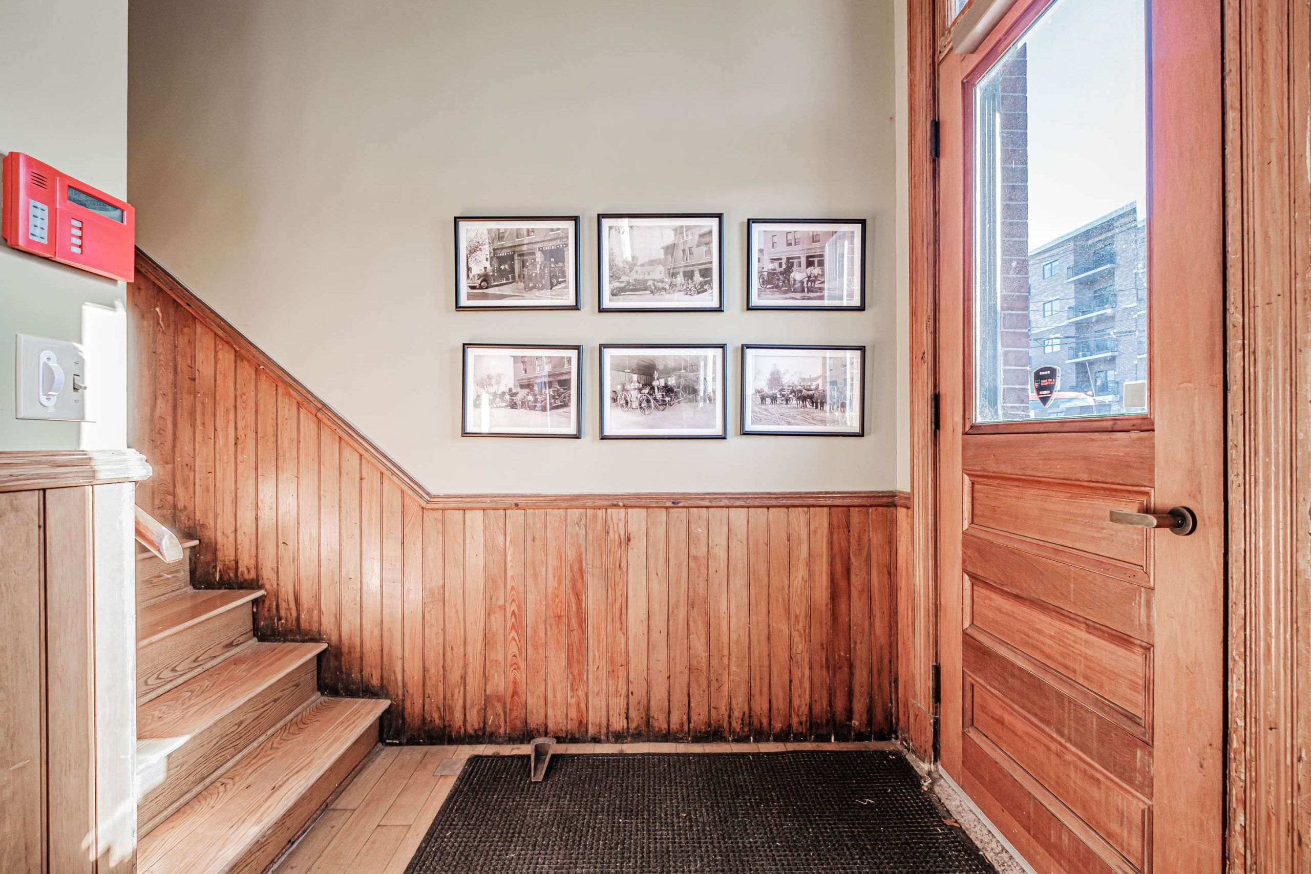 hall and stairs with woodwork and door and pictures